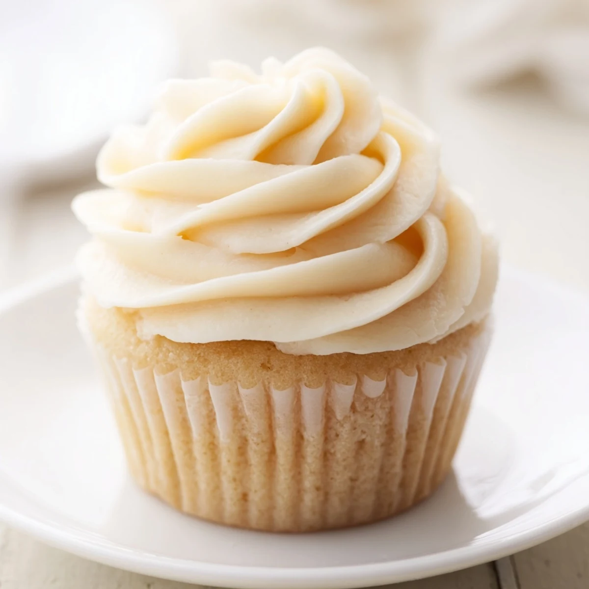 Close-up of freshly baked vanilla cupcakes with buttercream frosting, showing the creamy texture and sweet delight.
