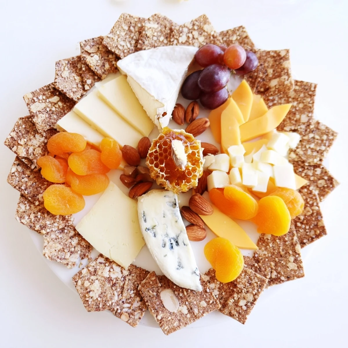 Glimpse The Gilded Hive, a cheese and cracker board, inviting with its honeycomb centerpiece and radiating cheese.