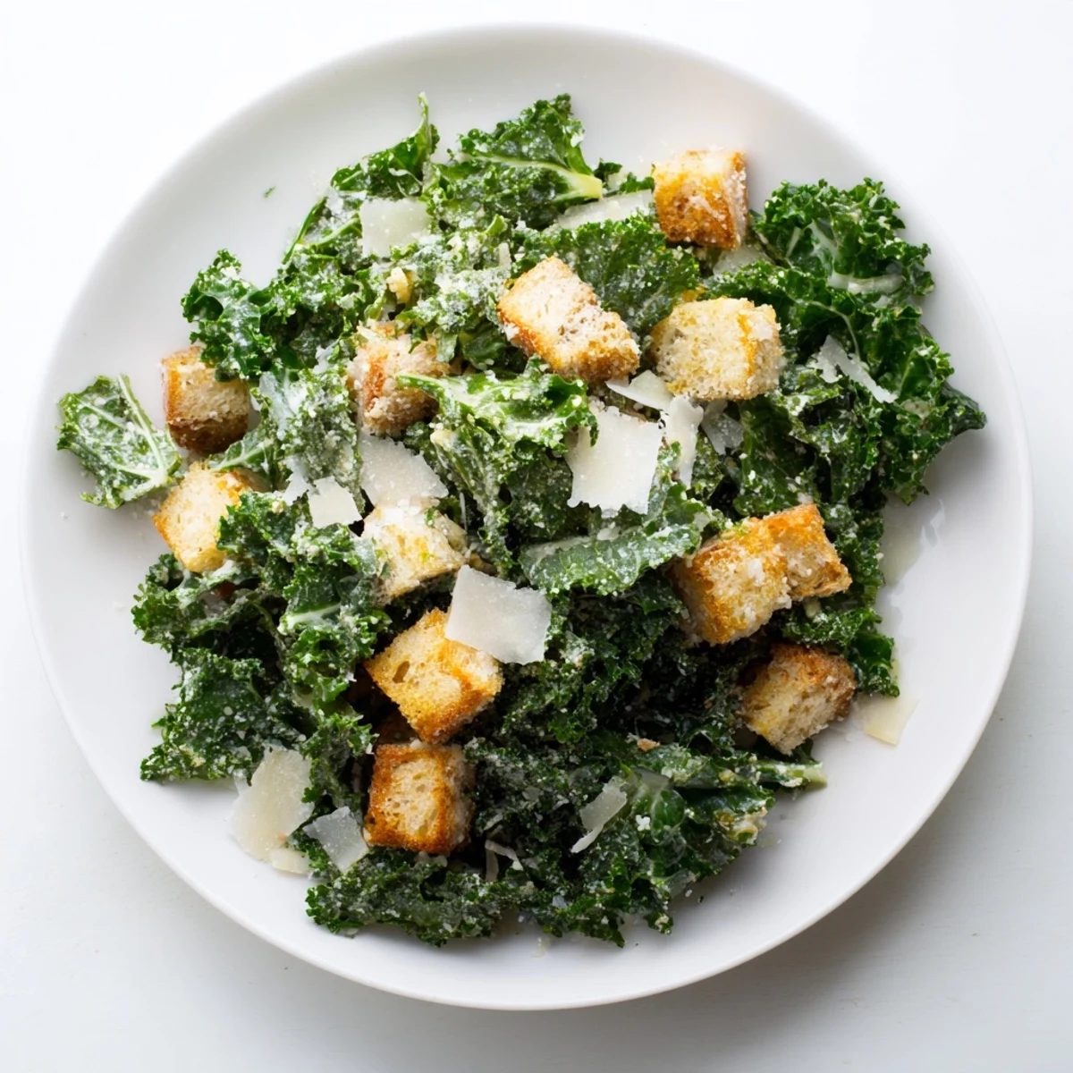 Freshly tossed Kale Caesar Salad with crispy croutons and shaved Parmesan, a delicious lunch.