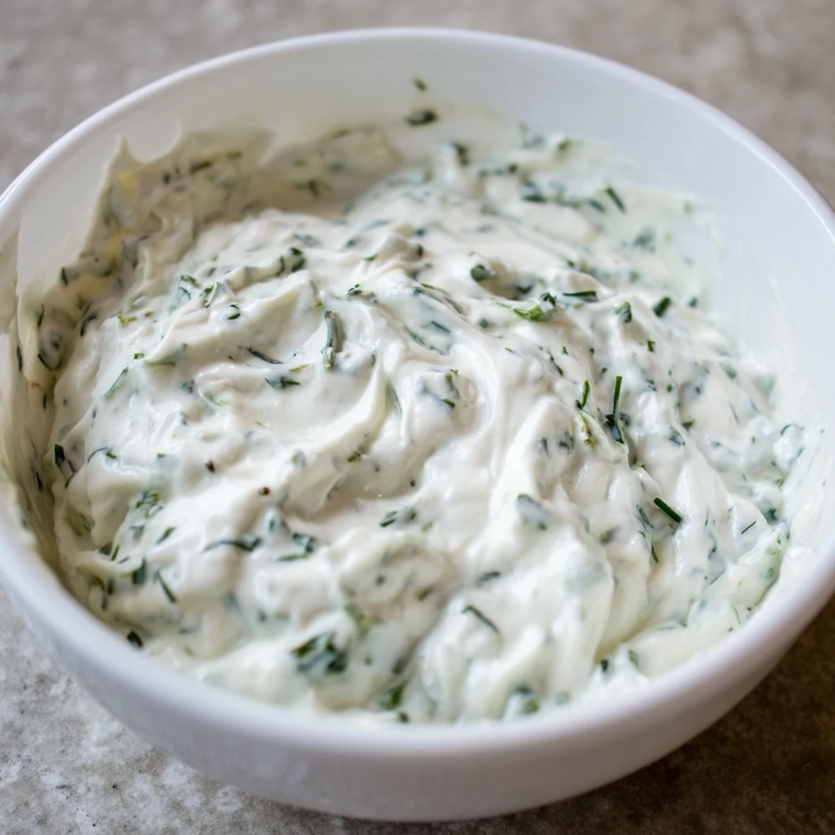 Freshly made Green Goddess Salad Dip in a rustic bowl, paired with colorful carrot and cucumber crudités.