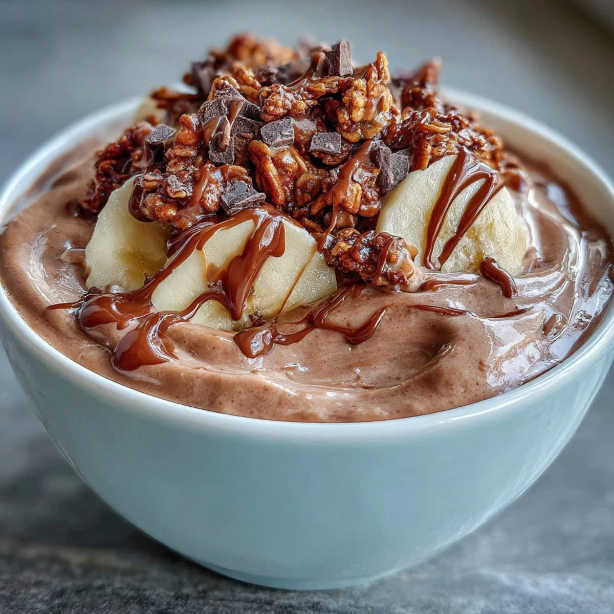 Thick and creamy Chocolate Peanut Butter Smoothie Bowls in a white bowl, drizzled with extra peanut butter for a decadent breakfast.
