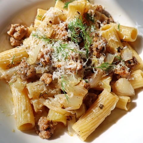 Steaming Winter Pasta with Sausage and Fennel in a skillet, tossed with golden fennel slices and fresh parsley.  