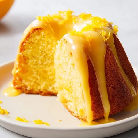 A beautiful, close-up shot of homemade lemon loaf cake drizzled with sweet lemon glaze.