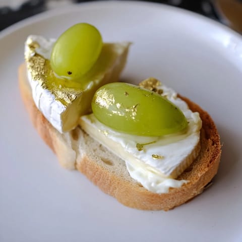 Close-up of Sparkling Champagne Toasts; creamy cheese and prosecco-soaked grapes offer a delightful bite.