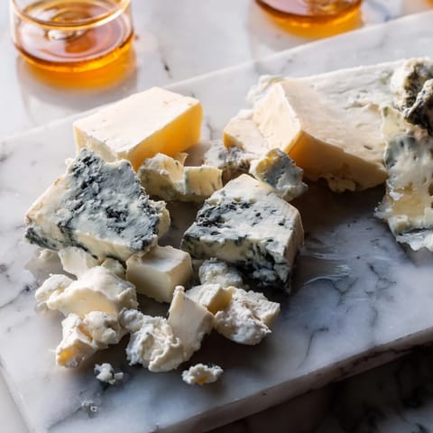 A close-up of The Marble Quarry appetizer: Irregular cheese pieces mingling for a visual feast.