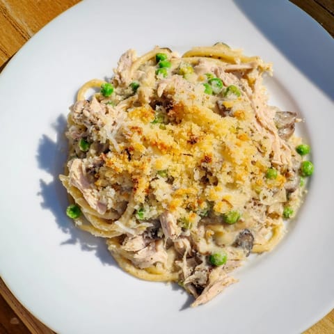 A close-up of creamy Turkey Tetrazzini, showing tender chicken, pasta, and melted cheese, perfect for dinner.