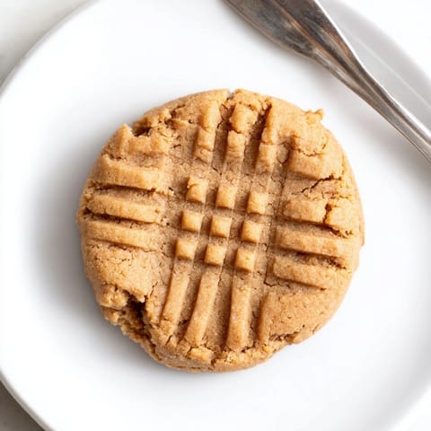 Close-up of perfectly textured flourless peanut butter cookies, slightly cracked and ready to eat.