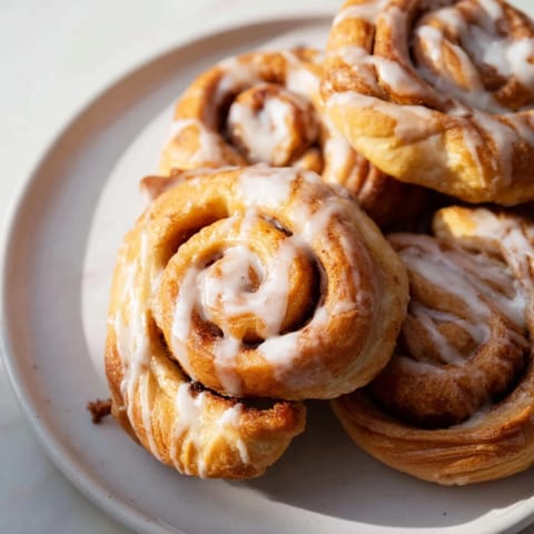 Air-Fryer Cinnamon Roll Twists, coated in sweet glaze, offer a warm, comforting, and delicious serving.