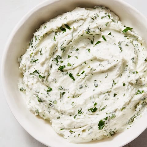 Close-up of Green Goddess Salad Dip, showcasing its bright green herbs and smooth, tangy texture in a serving bowl.