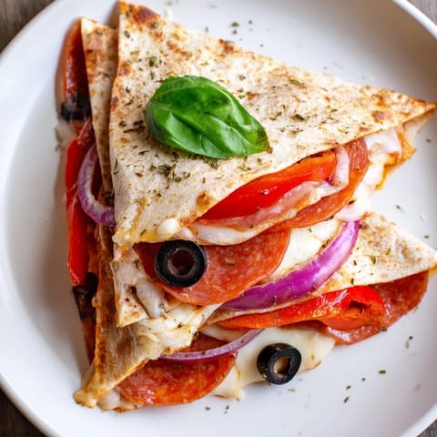A close-up of a perfectly pan-toasted Tortilla Pizza Wrap, showing melted cheese and fresh basil garnish ready to serve.  