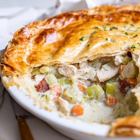 Savory Chicken and Leek Pie served in a rustic dish, with a crisp, buttery crust brushed with egg wash.