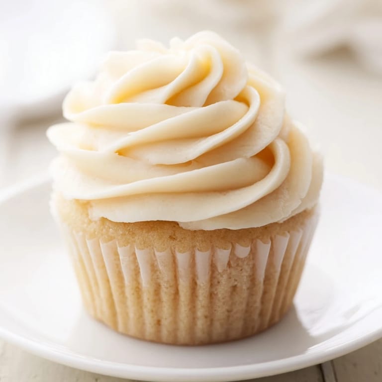 Close-up of freshly baked vanilla cupcakes with buttercream frosting, showing the creamy texture and sweet delight.