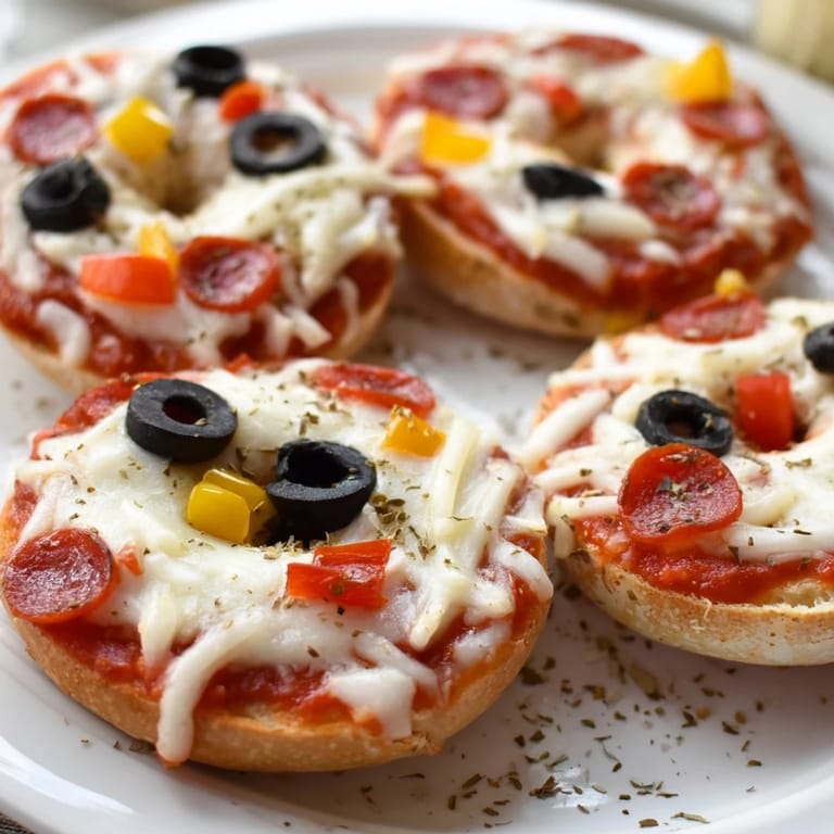 Close-up of air-fried mini bagel pizzas, showing the melty cheese and crispy bagels.