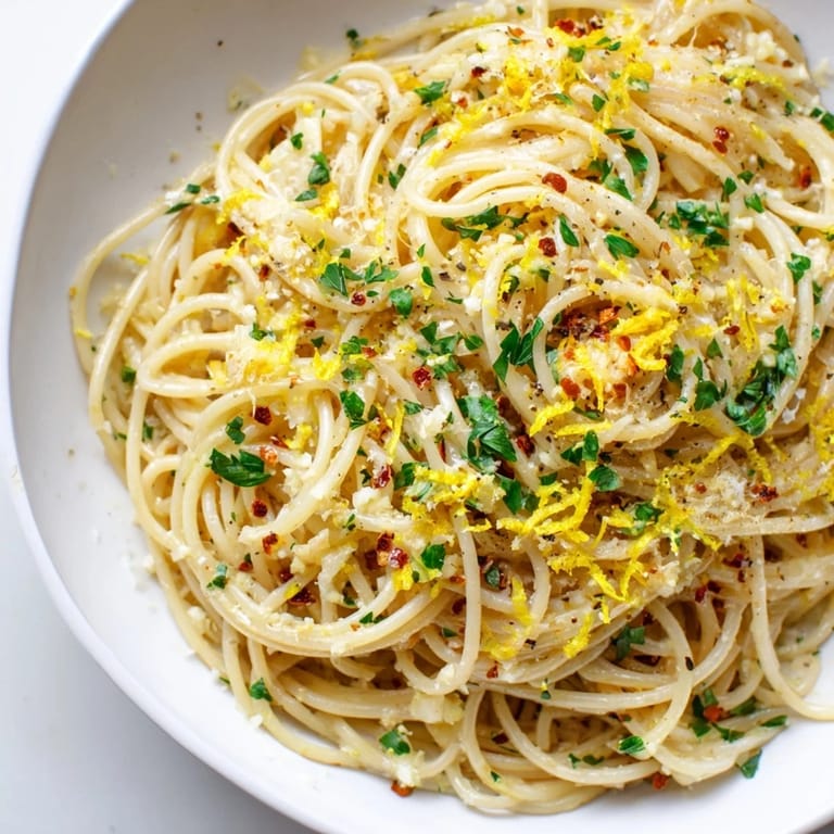 A close-up of steaming garlic butter noodles, garnished with parsley and ready for a savory bite.