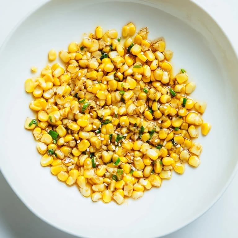 A close-up of buttery, savory Japanese butter corn sprinkled with scallions, a perfect simple side dish.