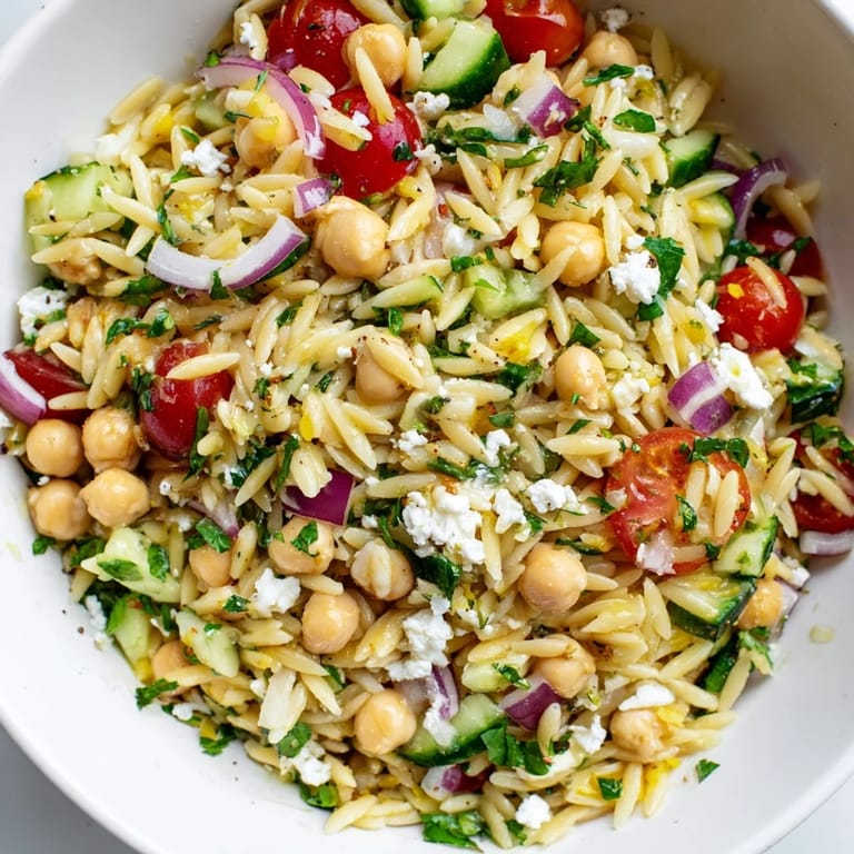 Close-up of Lemony Chickpea Orzo Salad showcasing tender chickpeas, diced cucumber, and a drizzle of bright lemon vinaigrette.